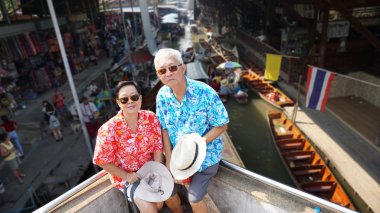 Asian elderly couple having retirment trip to Thailand floating  clipart
