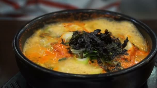 Colher levando bolinho de massa de guisado picante coreano servir em panela quente — Vídeo de Stock