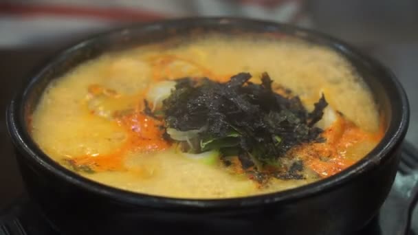 Korean style boiling spicy dumpling stew serve in hot pot — Stock video