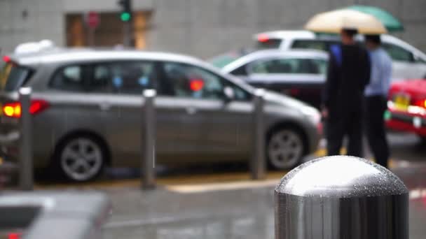 Asian people in Hong Kong crossing road traffic while raining. Business working district people walk with umbrella — Stock Video