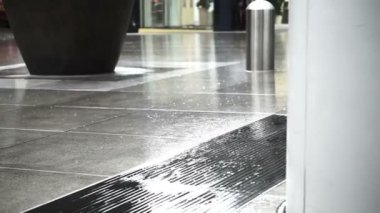 Asya yayalar yağmur iş bölgesi alanında üzerinde yürürken zemin ıslak