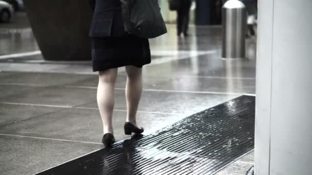 Silhouette of Asian pedestrians in business area walking on rainy building pavement — ストック動画