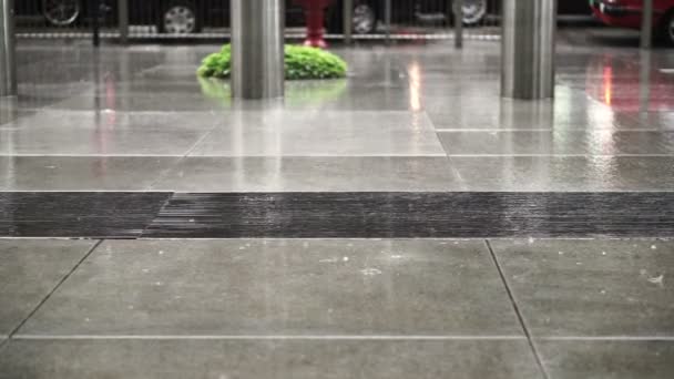 Silhouette of Asian pedestrians in business area walking on rainy building pavement — Stock video