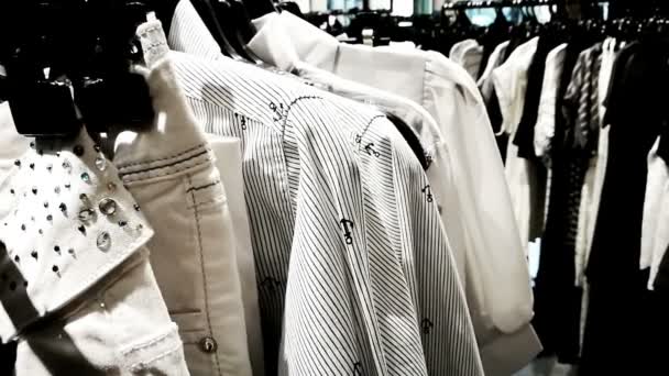 Black and white theme clothes hanging in fashion shop racks — Stock Video