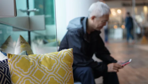 Uomo anziano asiatico che usa lo smart phone. Comunicare con la famiglia attraverso la tecnologia — Foto Stock