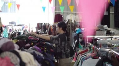 Asya karışık ırk kadın bit pazarı ambarında ikinci giyim alışveriş