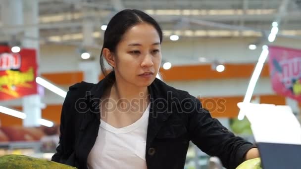 Ázsiai bevándorló nő bevásárlás a gyümölcs a szupermarketben. Absztrakt nehéz gazdasági időszakban — Stock videók