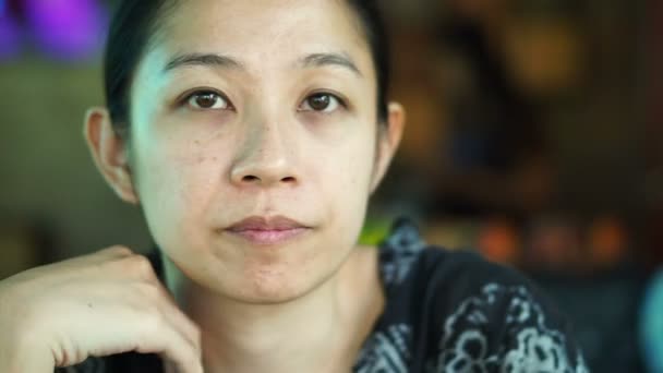 Азиатские женщины смешанной расы сидят и смотрят в сторону, думая — стоковое видео