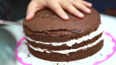Pastane chef dekorasyon çikolata sünger kek pişirme. Beyaz krema orta katmanlarında koyarak