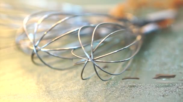 Whisks de acero inoxidable colocados sobre mesa de vidrio en cocina moderna — Vídeos de Stock