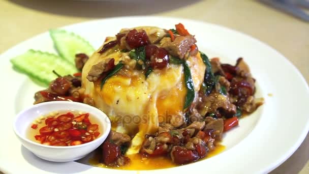 Местные блюда тайской кухни, пряная свинина базилик размешать картошку фри с жареным яйцом над рисом — стоковое видео
