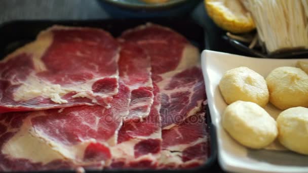 Japanese, Chinese hot pot shabu style. Sliced beef, fish cheese balls and vegetable — Stock Video