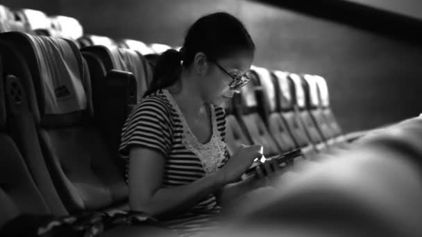 Aziatische vrouw met behulp van mobiele telefoon in een lege bioscoop theater. Zet uw telefoon vóór film concept — Stockvideo