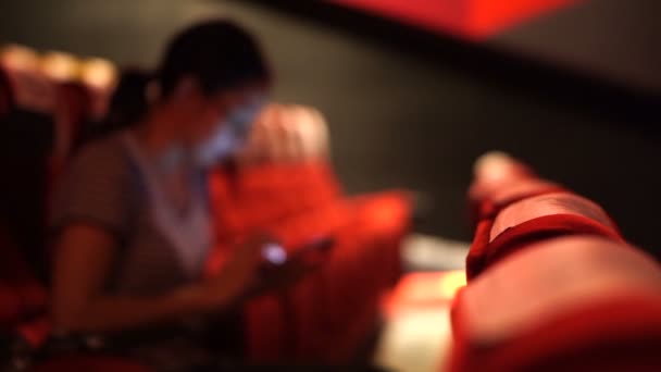 Mujer asiática usando teléfono inteligente en el cine cine, mal hábito de la adicción a las redes sociales — Vídeos de Stock