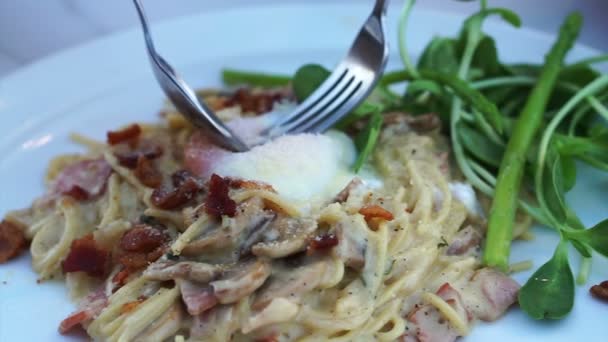 Comer espaguete carbonara com garfo e misturar gema de ovo cru em — Vídeo de Stock