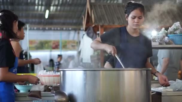 Puesto de comida de la calle sirven desayuno en la tienda de sopa local en el mercado húmedo de Tailandia — Vídeo de stock
