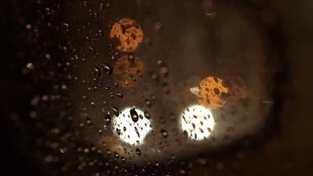 美丽的五颜六色的模糊灯光的交通在道路上。挡风玻璃上的雨水流动 — 图库视频影像