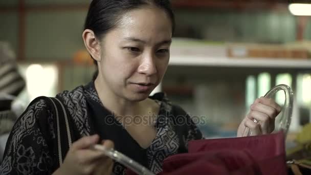 Aziatische vrouw in de stemming te winkelen. Gelukkig kiezen en kijken naar kleding en accessoires in tweedehands magazijn winkel — Stockvideo