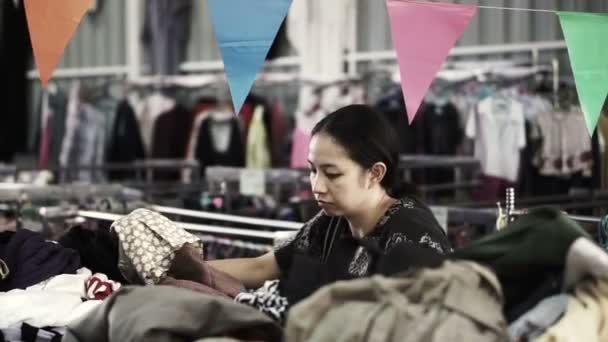 Sud-Est asiatique fille à la recherche de vêtements de grand magasin avec des tonnes et des piles d'accessoires de mode — Video