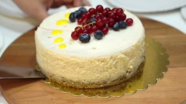 Bıçak kesim bütün İngiliz lirası-in cheesecake üstüne çilek ile