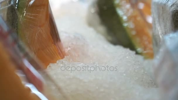 Cantaloupe fatiado embrulhado em pacote de plástico no gelo no supermercado. Pronto para comer frutas — Vídeo de Stock