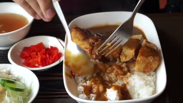 Asya'ya ait adam Japon köri ile tonkatsu, yiyecek öğle yemeği kümesindeki kızarmış domuz eti yemek — Stok video