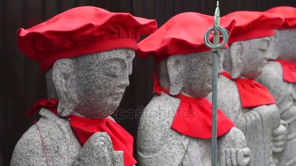 Japanese buddhist stone monk statues wearing red clothes standing in row at temple front — Stock Video