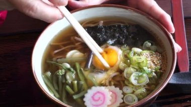 Japon soba noodle çorba yemek, yemek çubukları kapış çiğ yumurta sarısı için kullanarak el