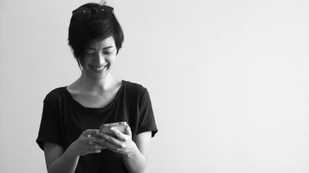 Coole asiatische Hipster-Mädchen mit modernem Look lächeln und lachen, während sie das Smartphone benutzen — Stockvideo