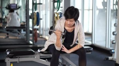Sportif serin Asyalı kadın eğitim halter salonunda kaldırma