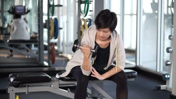 Sporty cool Asian woman training dumbbell lifting at gym — Stock Footage Sporty cool Asian woman training dumbbell lifting at gym Video Clip