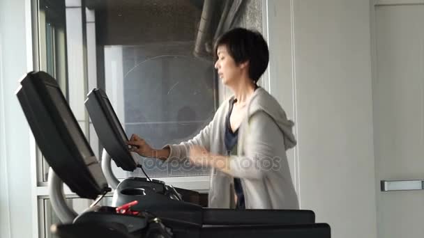 Asian mixed race sporty woman finish jogging on treadmill in gym, done for the day — Stock Video