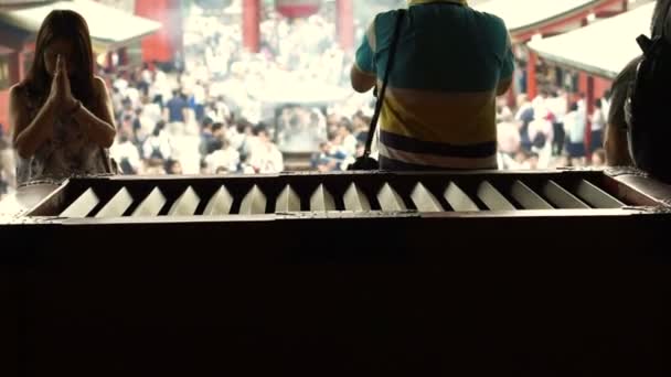 Tokyo, japan - september 2016: senso-ji tempel im asakusa gebiet. Rückansicht von innen zurück zu betenden Menschen und Menschenansammlungen auf dem Schreinplatz — Stockvideo