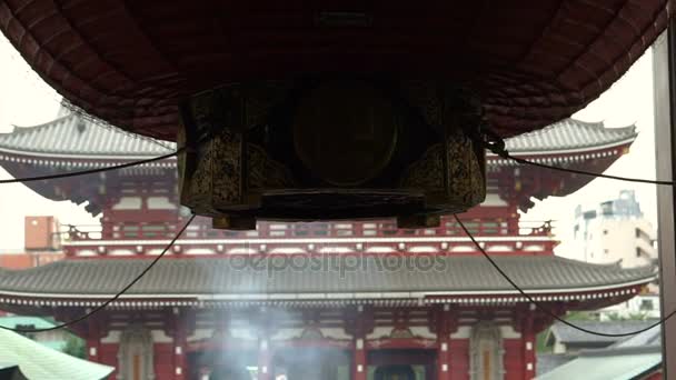 Tokyo, Japan - September 2016: Senso-ji tempel in Asakusa gebied. Omgekeerde uitzicht vanaf binnen terug naar mensen bidden en menigte in schrijn plaza — Stockvideo