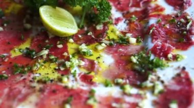 Dana carpaccio meze yemek, zeytinyağı, sarımsak ve limon ile ham sığır eti dilimlenmiş doku kadar kapatın