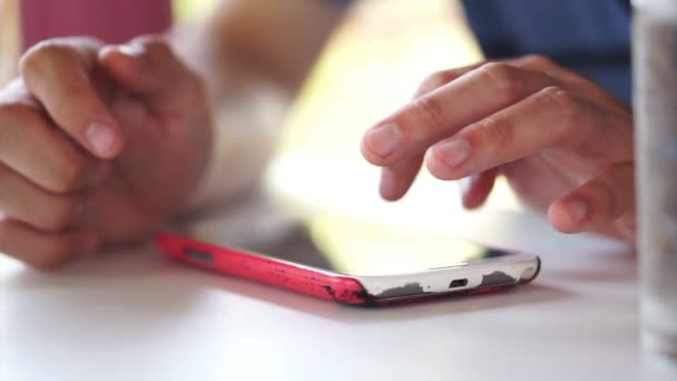 Mãos de homem usando antigo telefone inteligente riscado, em seguida, mostrando foto para mulher — Vídeo de Stock