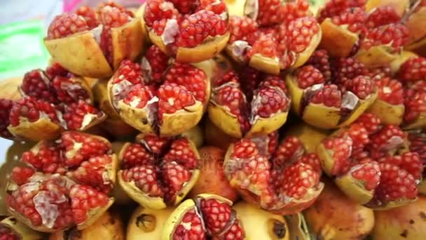 Pile of cut ruby red pomegranate fruit in Asia local market — Stock Video
