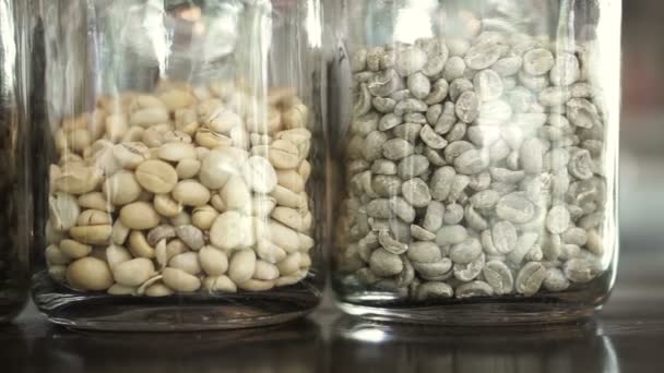 3 olika nivåer av rostade kaffebönor i glas burk, ljus, medium och dark roast — Stockvideo