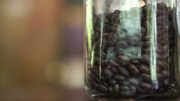 3 различных уровней жареных кофейных зерен в стеклянной банке, легкий, средний и темный жаркое — стоковое видео
