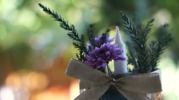 Vase de fleurs violettes et bougie avec fond de jardin vert nature — Video