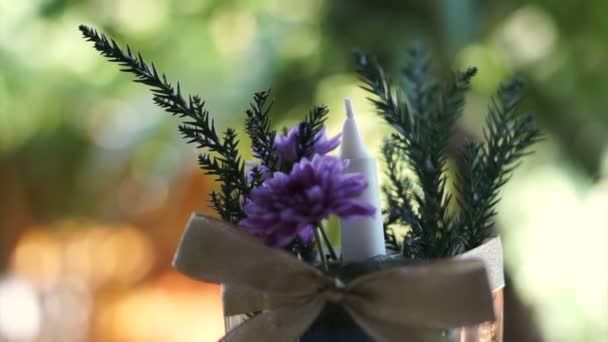 Florero de flor púrpura y vela con fondo verde jardín naturaleza — Vídeo de stock