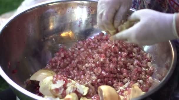 Hand peeling pomegranate seeds to make juice in Asian street food market — Stock Video