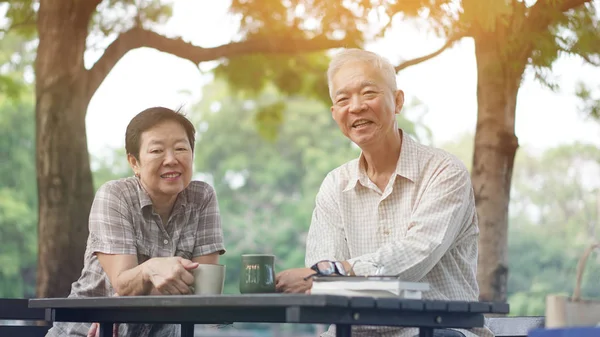 Asian senior couple start morning coffee in park, optimistic and bright concept — Stock Photo, Image
