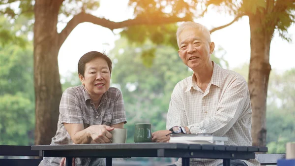 Asian senior couple start morning coffee in park, optimistic bright concept — Stock Photo, Image