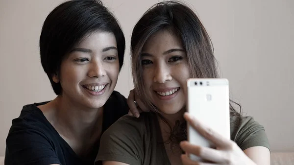 Две взрослые азиатские женщины фотографируют, селфи с помощью клеточной фо — стоковое фото
