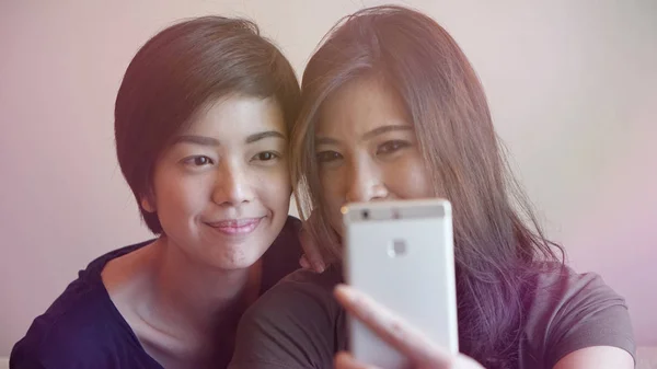 Duas mulheres asiáticas tirando foto, selfie usando telefone celular — Fotografia de Stock