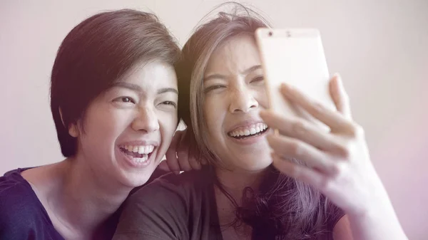 Dois mestiços meninas asiáticas tomando selfie com telefone inteligente — Fotografia de Stock