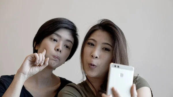 Två glada fotogenisk asiatiska kvinnans talar selfie med telefon — Stockfoto