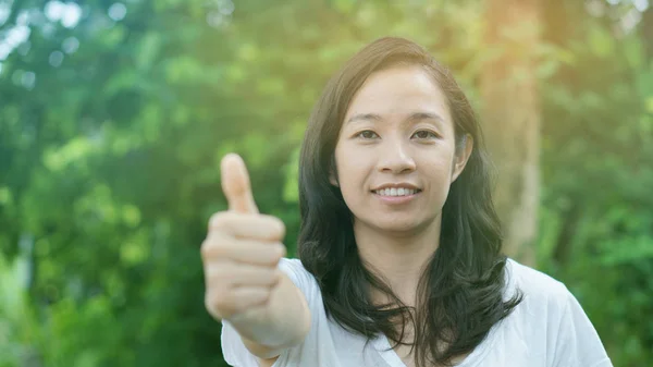 Kevert ázsiai lány hüvelykujj-up jellegű háttérrel — Stock Fotó