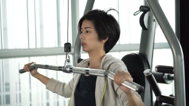 Asijské dospělé atletka, cvičení v posilovně fitness dělat stroj vzpírání — Stock video